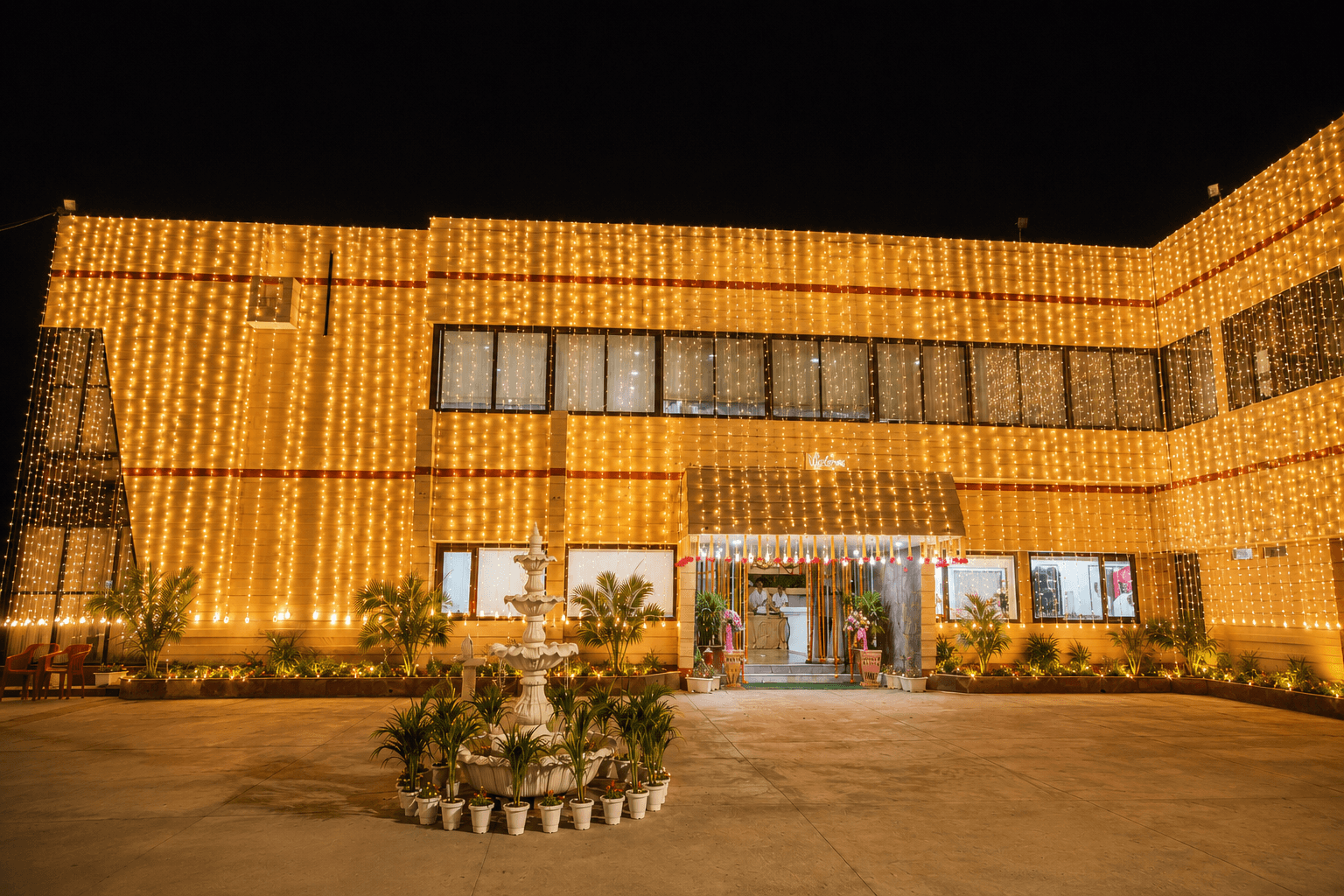 Hotel Vasant exterior illuminated for an evening celebration